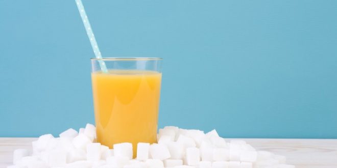 Glass of orange juice with plenty of sugar cubes