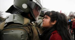 A demonstrator looks at a riot policeman during a protest marking the country s 1973 military coup in Santiago  Chile September 11  2016  REUTERS Carlos Vera FOR EDITORIAL USE ONLY  NO RESALES  NO ARCHIVE      TPX IMAGES OF THE DAY