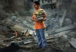 A boy saves a few books from the rubble of his home, a six storey apartment building which was bombed by the Israeli air force. The building was in the middle of a densely populated area in the city of Tyre. Three casualties were reported.